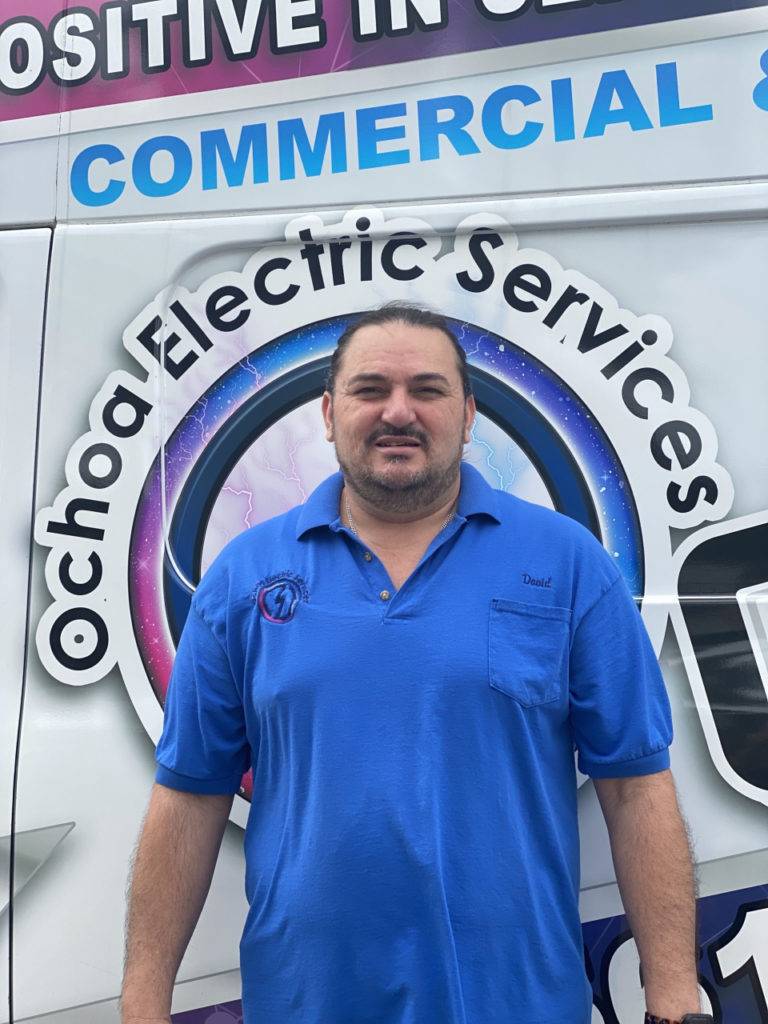 Licensed electrician near me from Ochoa Electric Services standing beside a service van in Palm Beach County FL performing electrical panel upgrades and installations.
